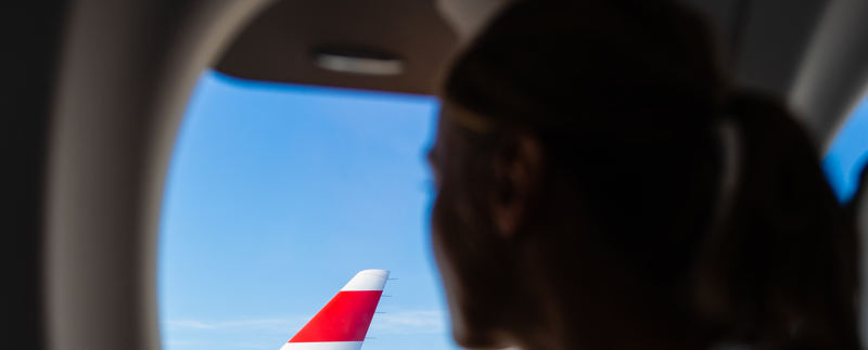 Kvinna ser ut genom flygplatsfönster.